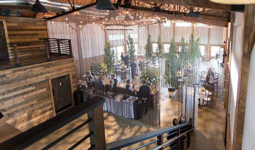 Dramatic image from second level looking down over beautifully decorated reception area. Live evergreens help complete the affect.