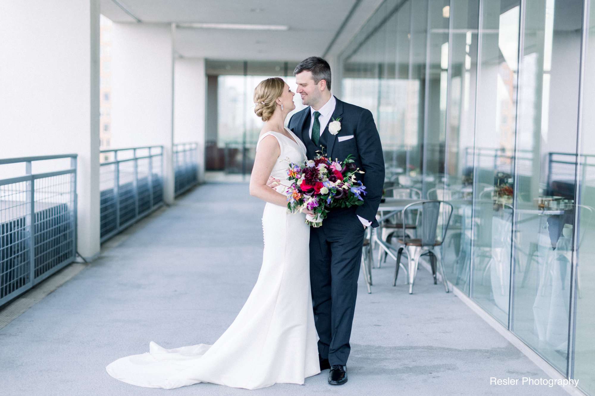 A couple posing for a romantic moment on the balcony of Jann Serr Studio, showcasing the urban skyline.