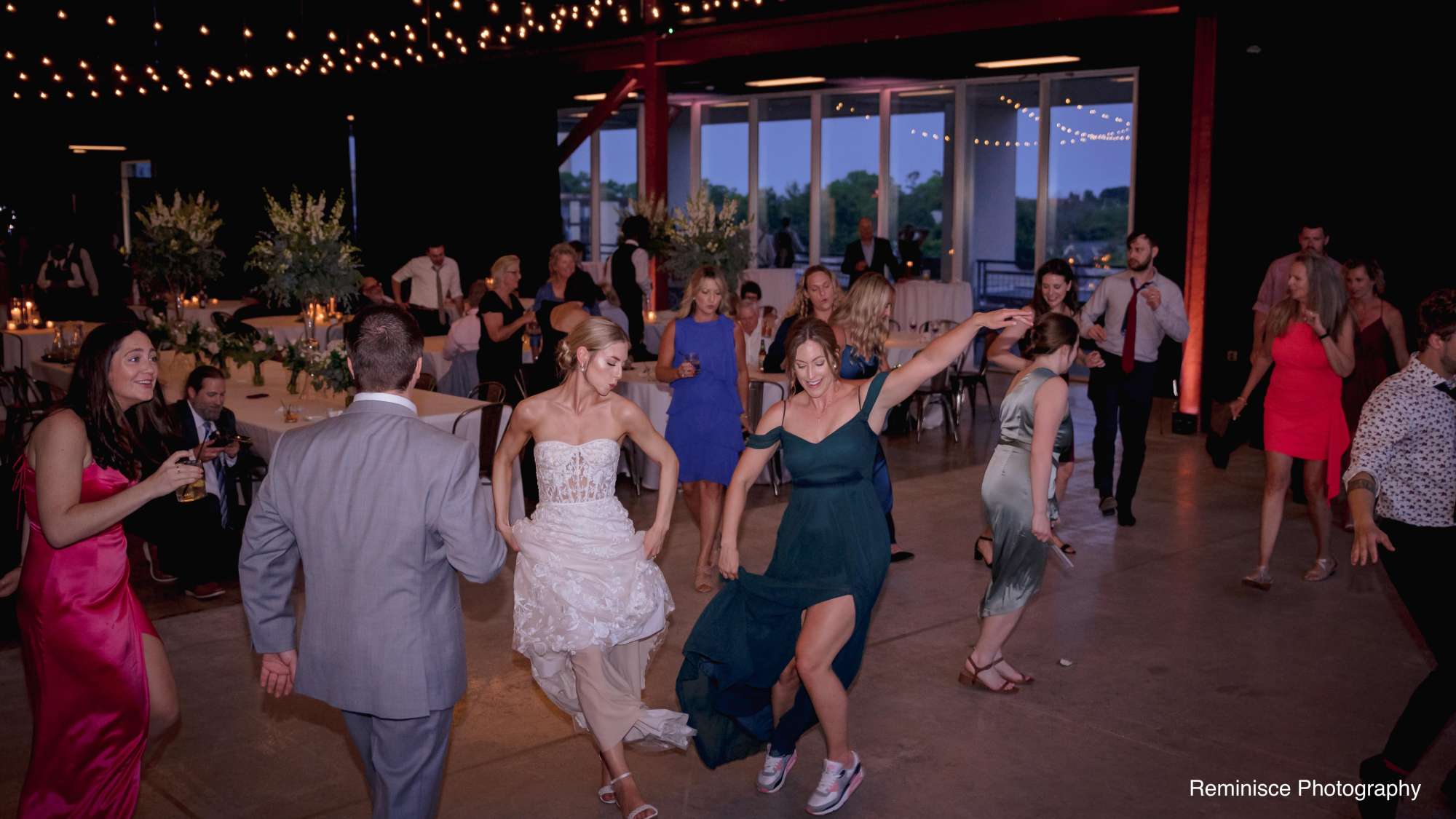 Brian and Emma enjoy their wedding reception surrounded by dancing guests at Jan Serr Studio.