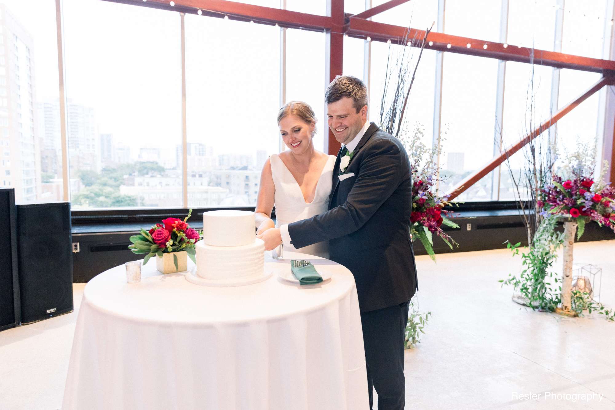 A couple cuts their wedding cake in the stunning event space of Jan Serr Studio.