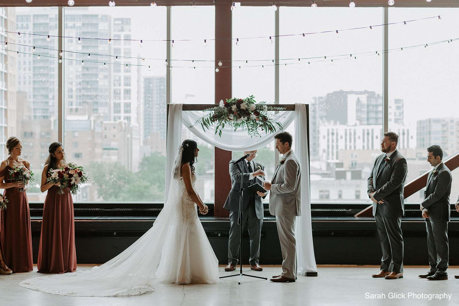 A wedding couple exchanges vows under a beautifully decorated arch at Jan Serr Studio.