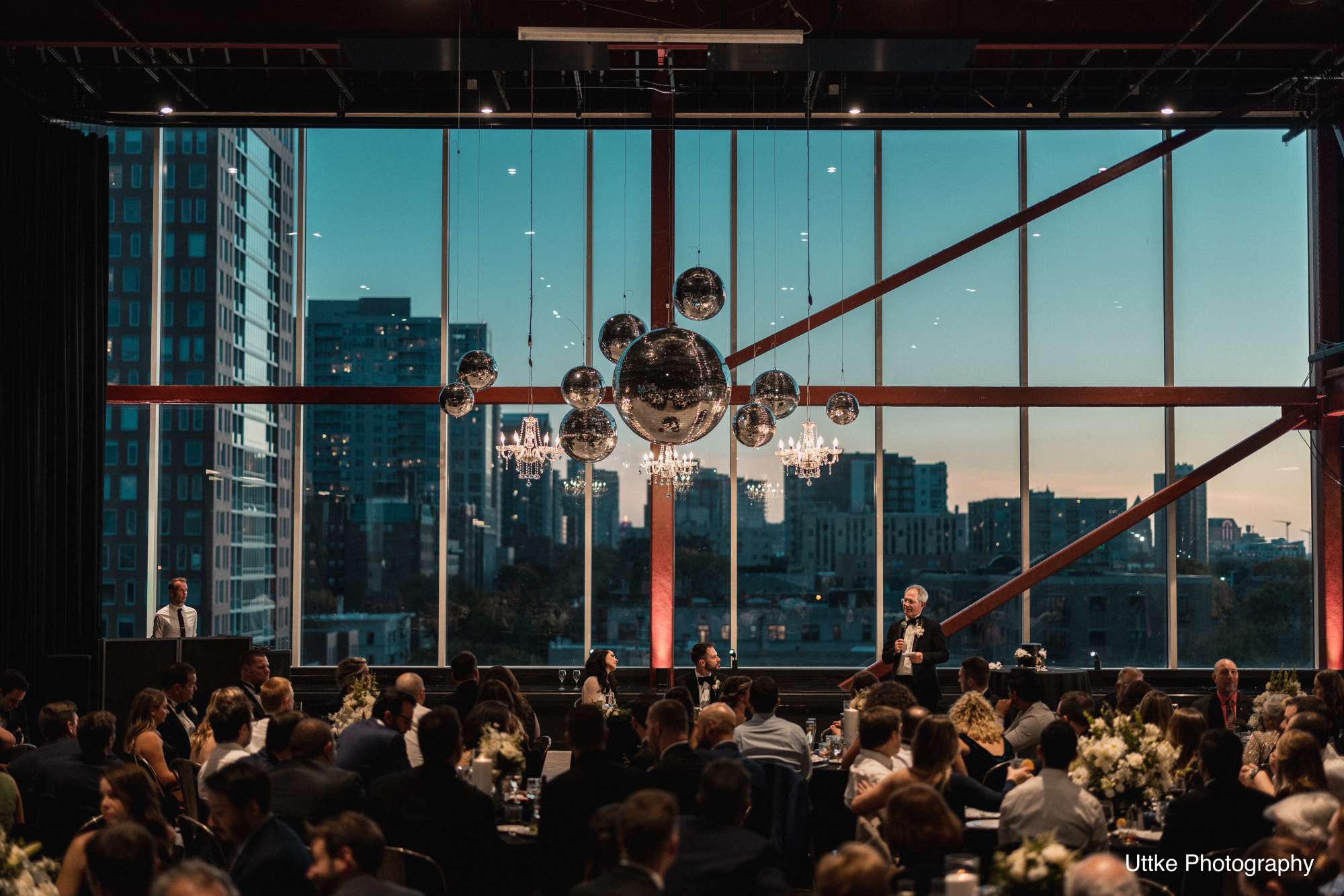 The venue illuminated with disco balls and chandeliers, creating a magical and modern ambiance for an evening reception.