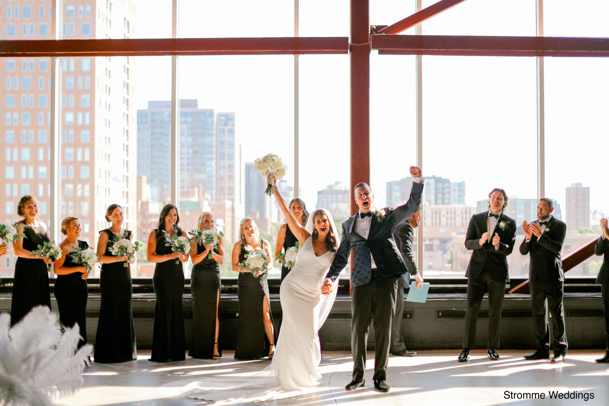 A jubilant couple celebrates with their wedding party after tying the knot at Jan Serr Studio.