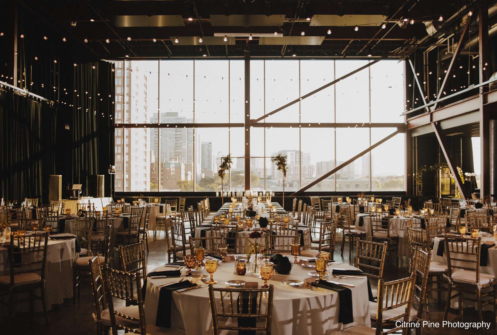 A wide view of Jan Serr Studio showcasing its expansive windows, sophisticated decor, and glowing lights.