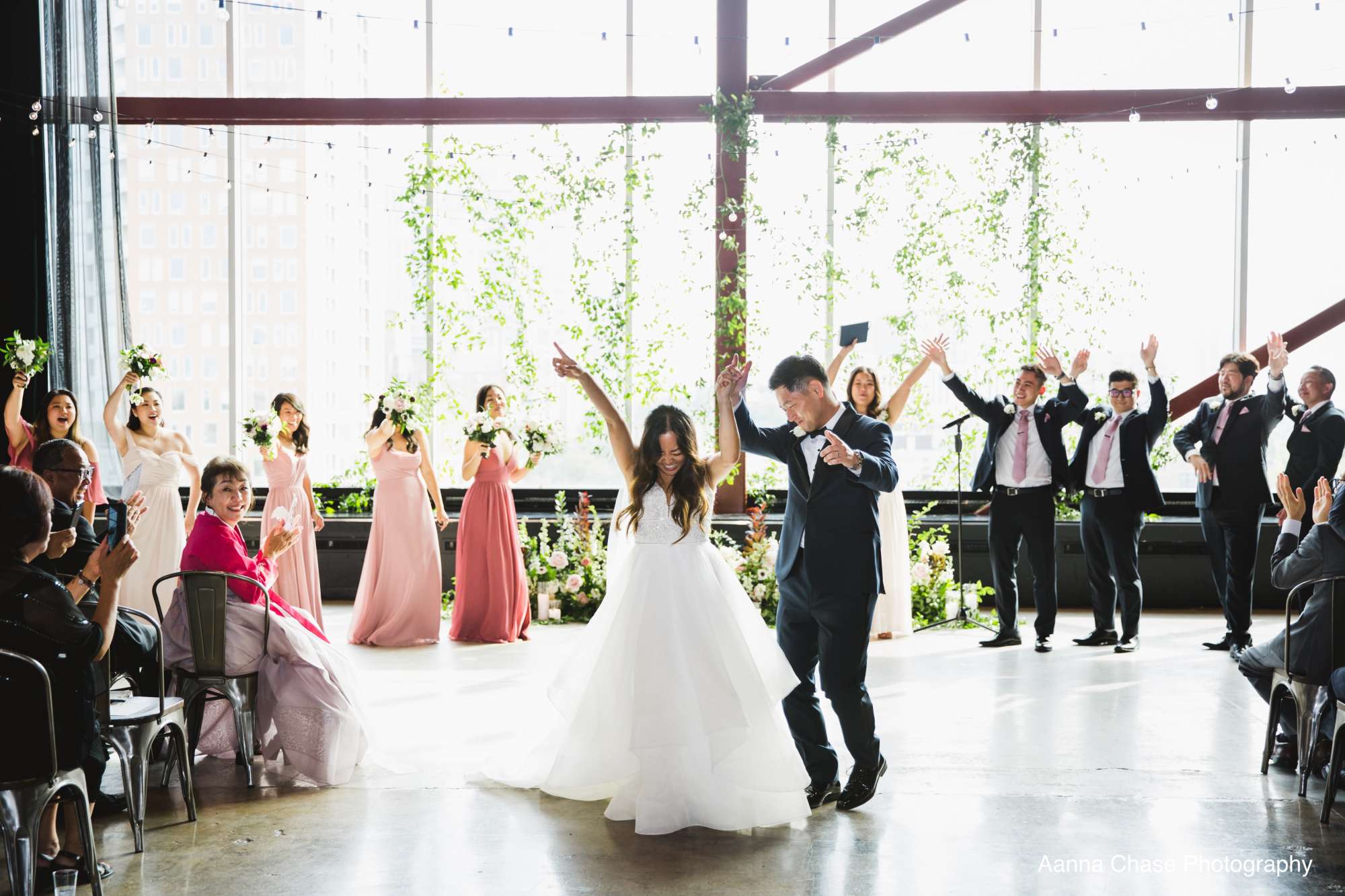 A breathtaking wedding ceremony at Jann Serr Studio, with a stunning backdrop of downtown city views and lush floral arrangements.