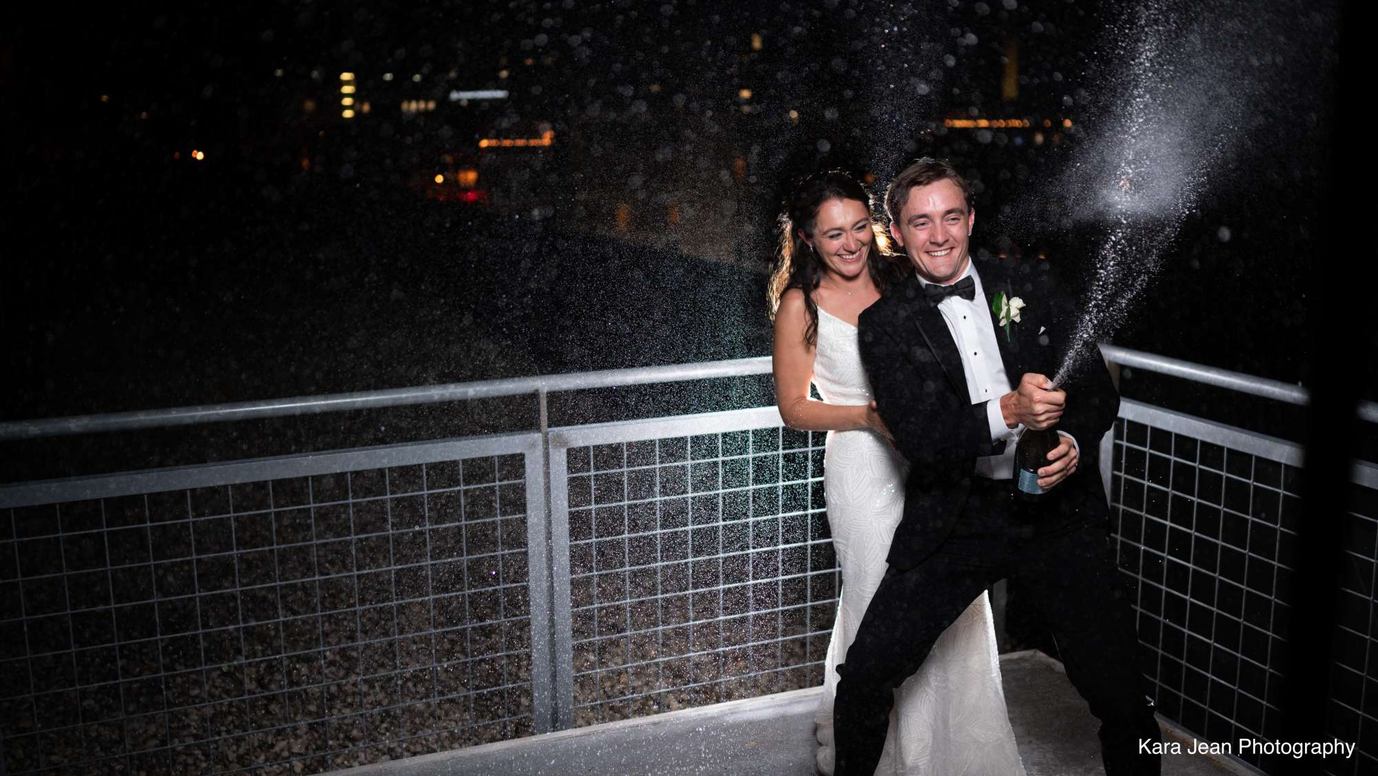 Cecilia and Andrew celebrate with champagne on the rooftop of Jan Serr Studio.