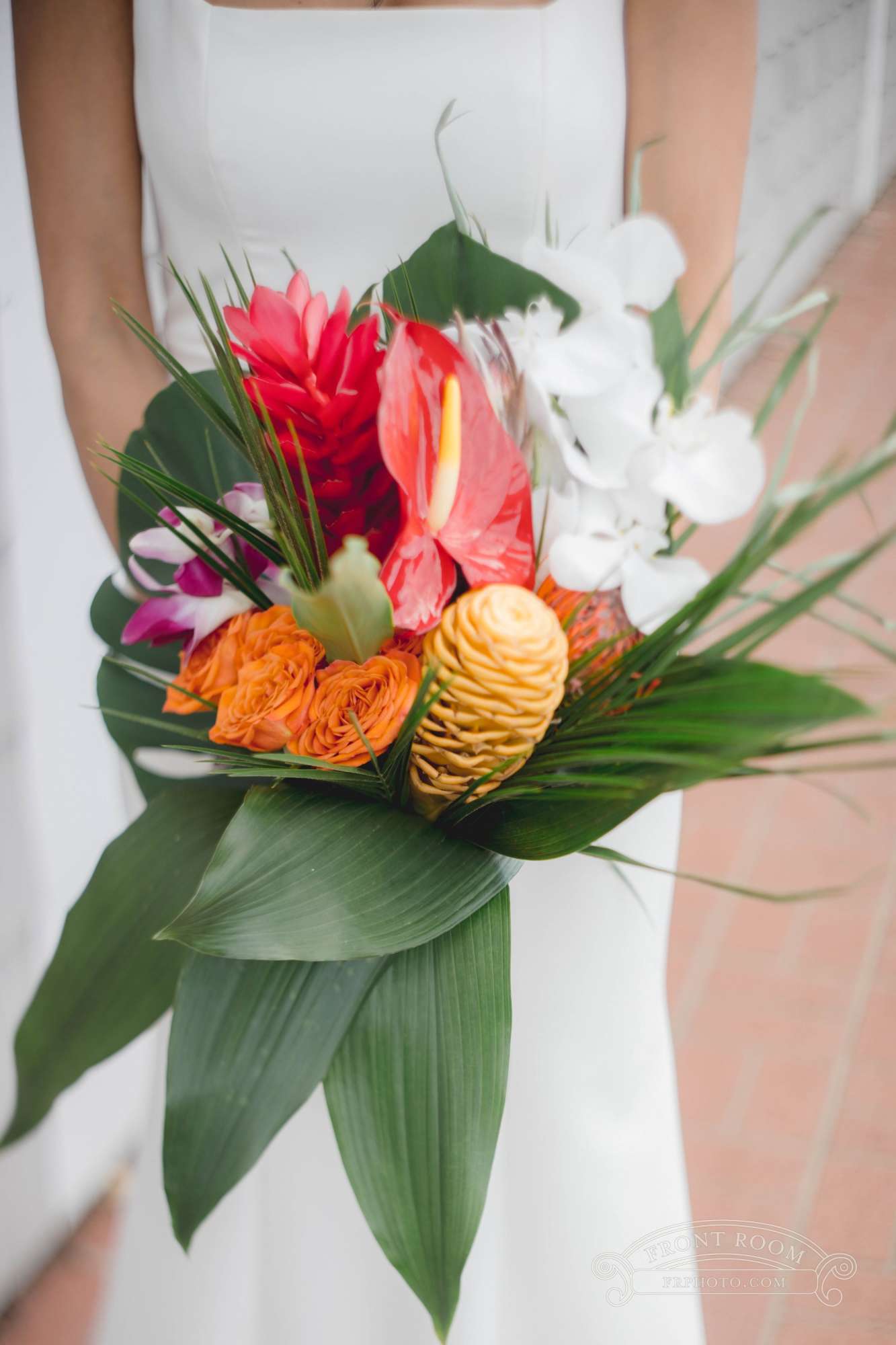 Ambrosia Events showcases a stunning tropical bridal bouquet featuring vibrant red, orange, and lush green accents for a bold wedding statement.