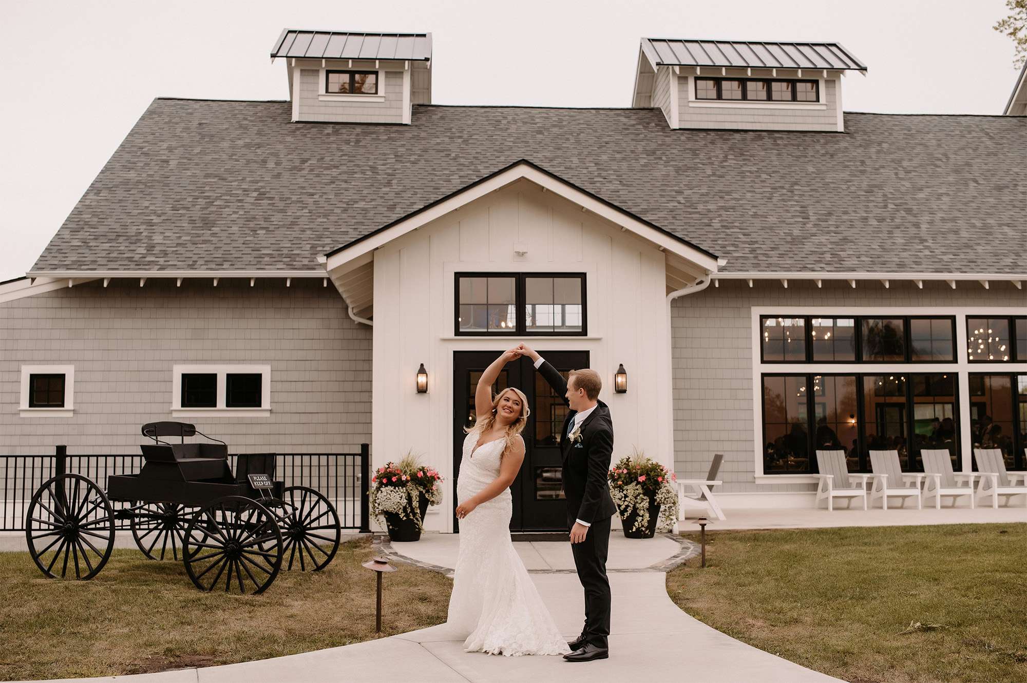 Bride twirls for groom outside The Carriage House at the Club at Lac La Belle.