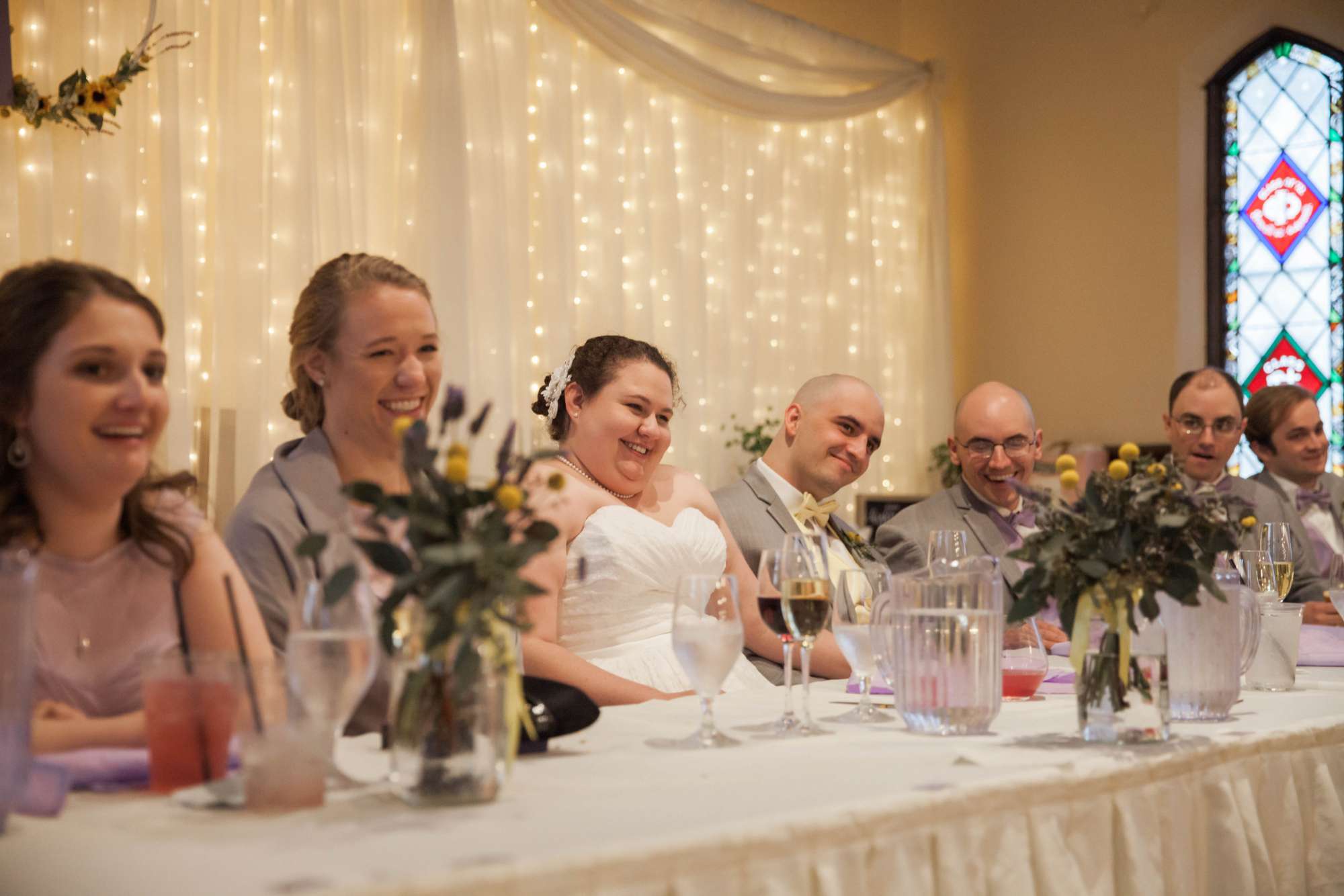 Bride and groom seated at the head table laugh