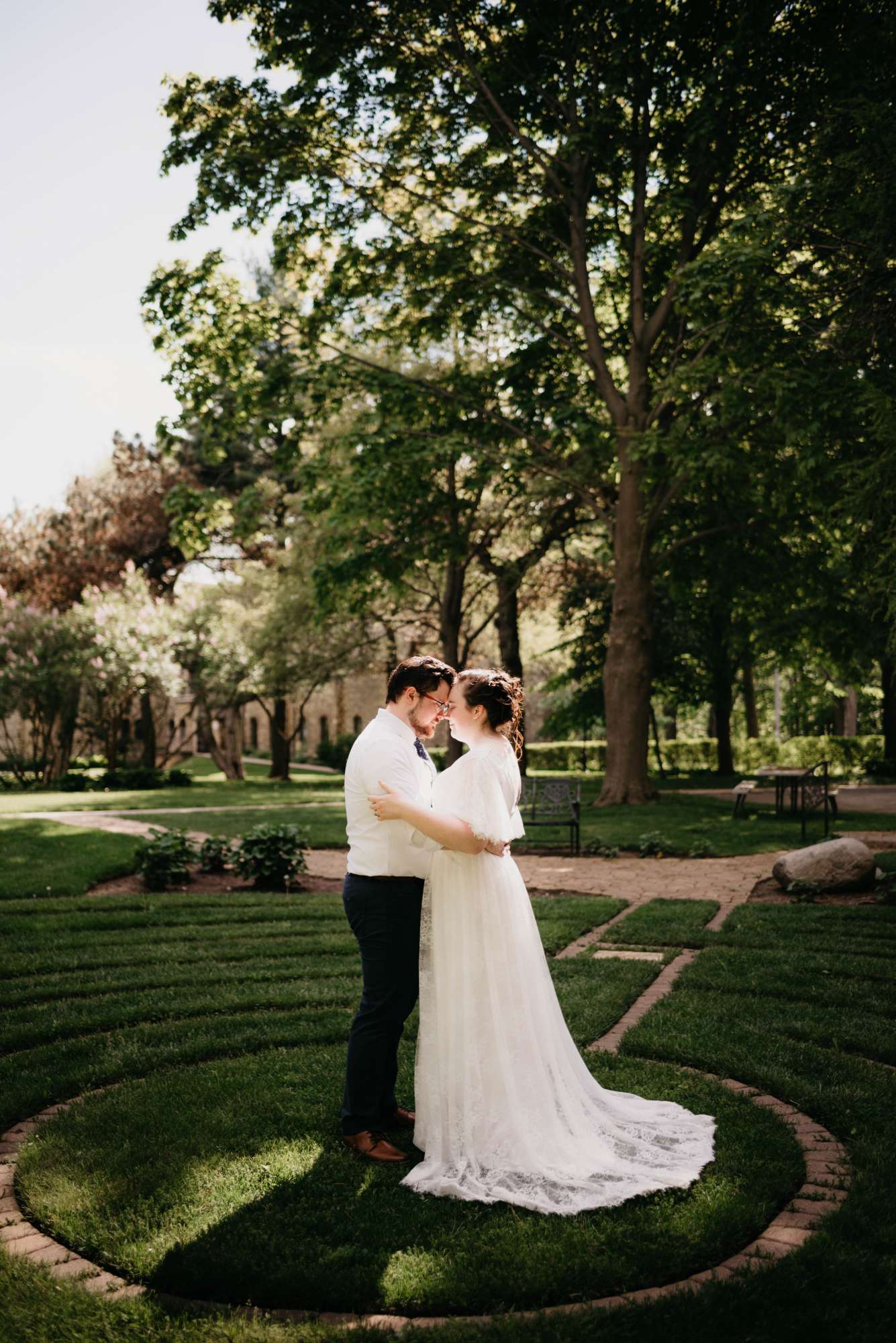 Bride and groom embrace on the ground of the Dekoven Center in Racine, WI