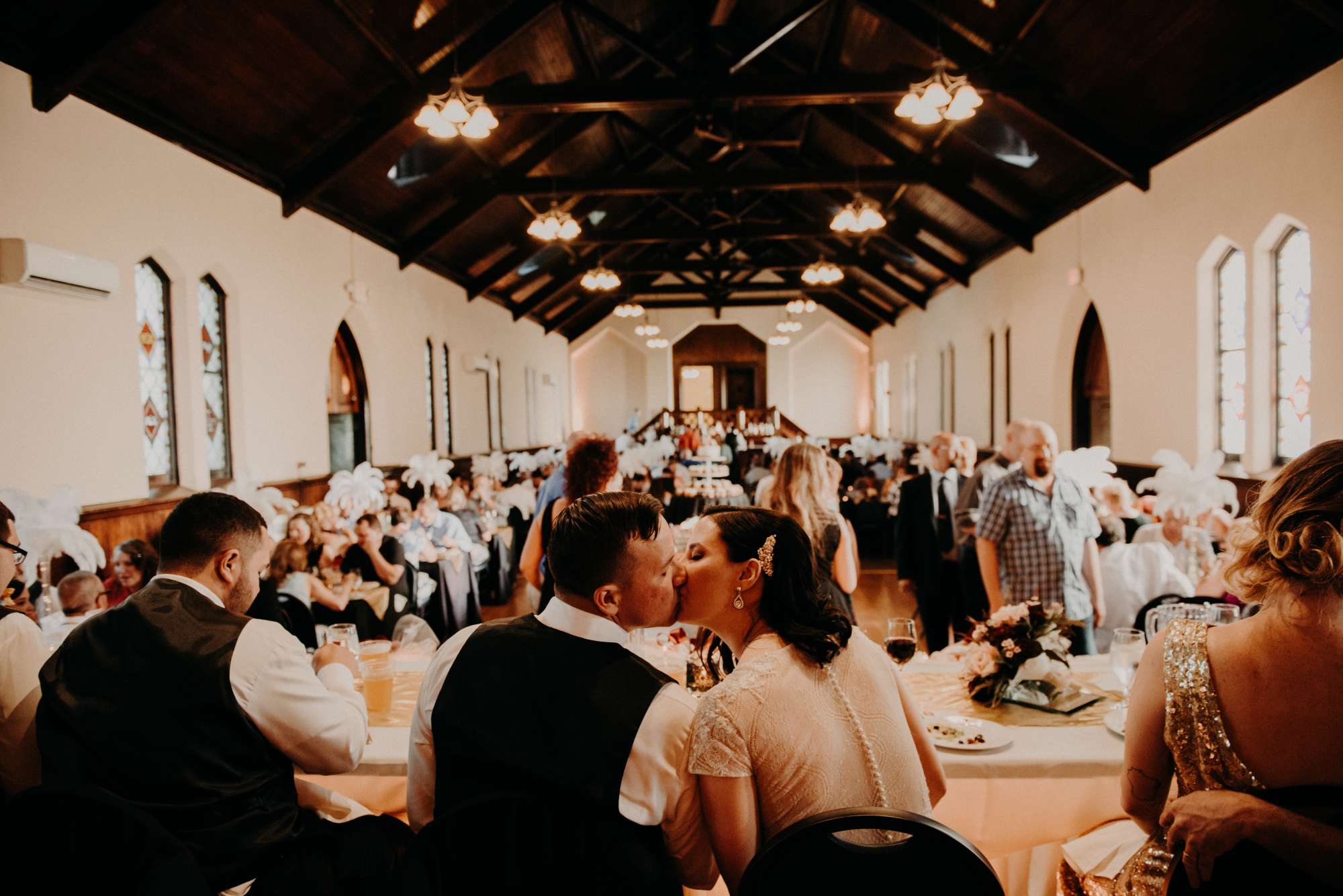 Bride and groom kiss at head table