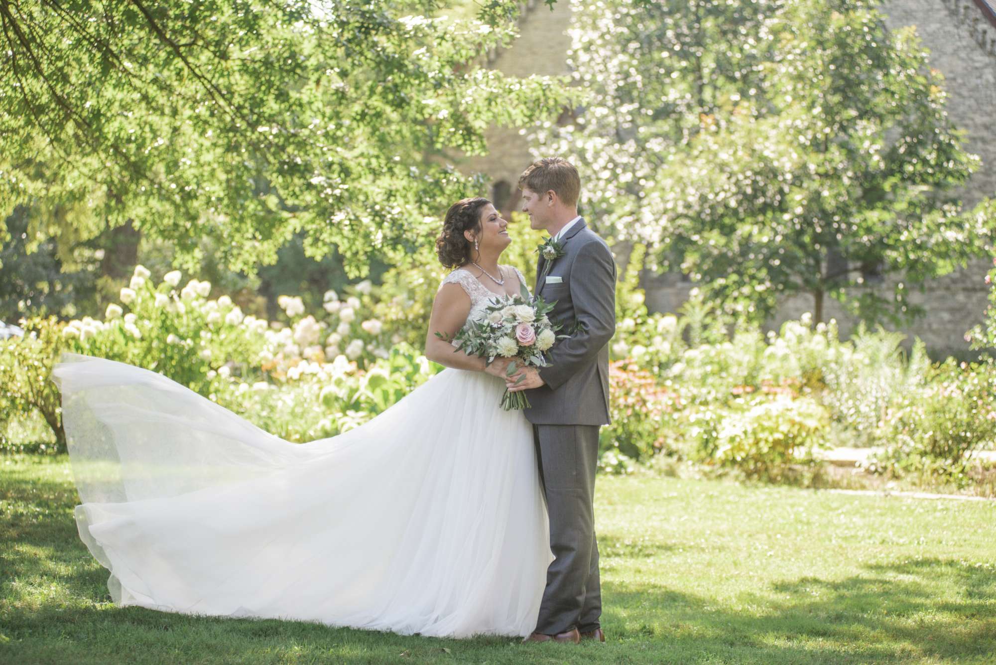 Bride with lush bouquet and groom