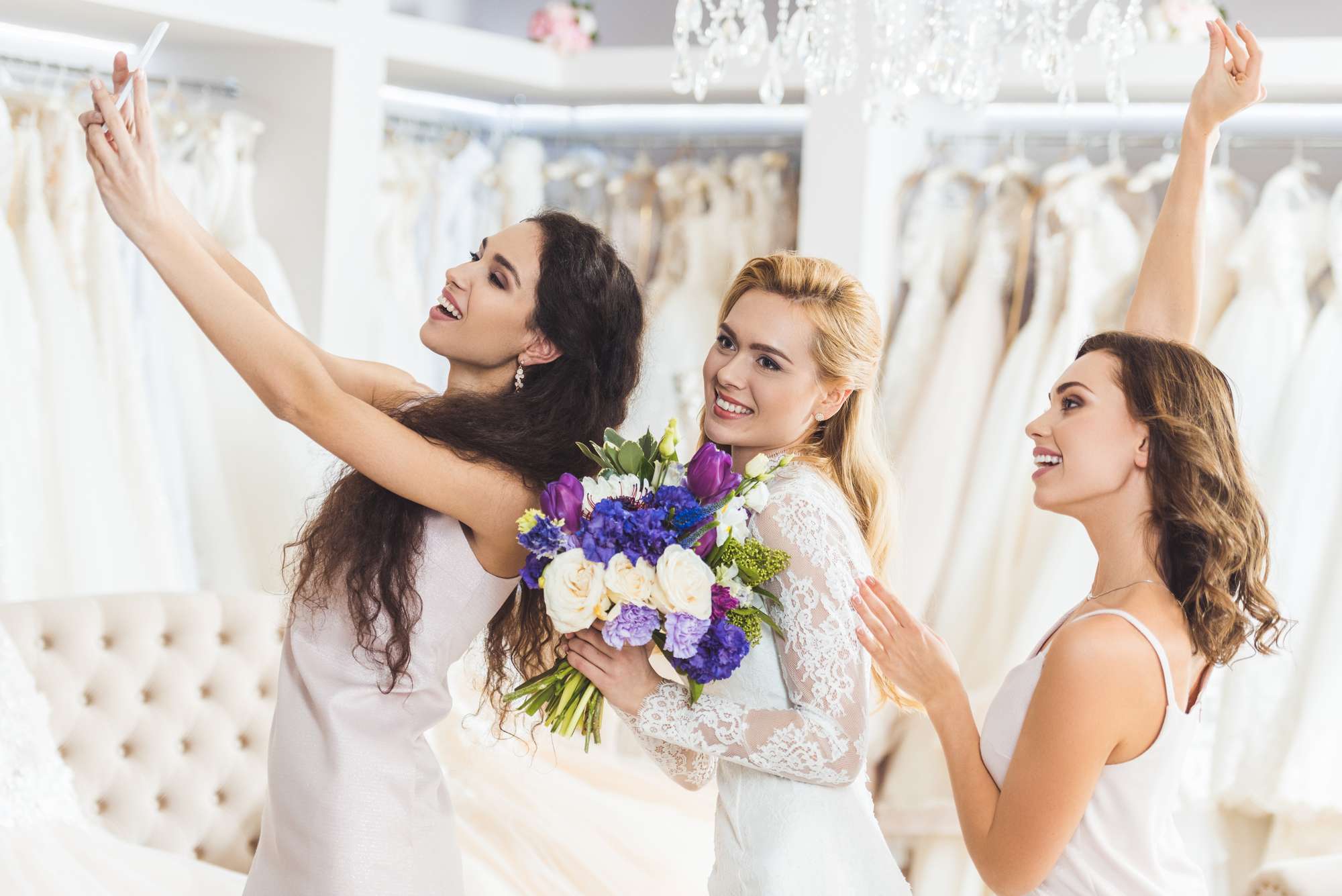 bride shopping with bridesmaids for wedding gown