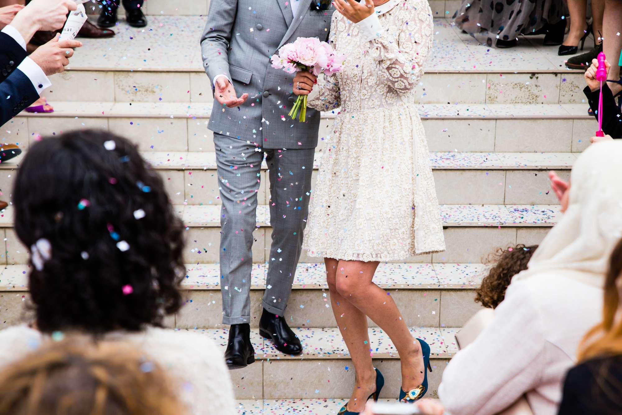 bride holds petite bouquet walking down stairs with groom