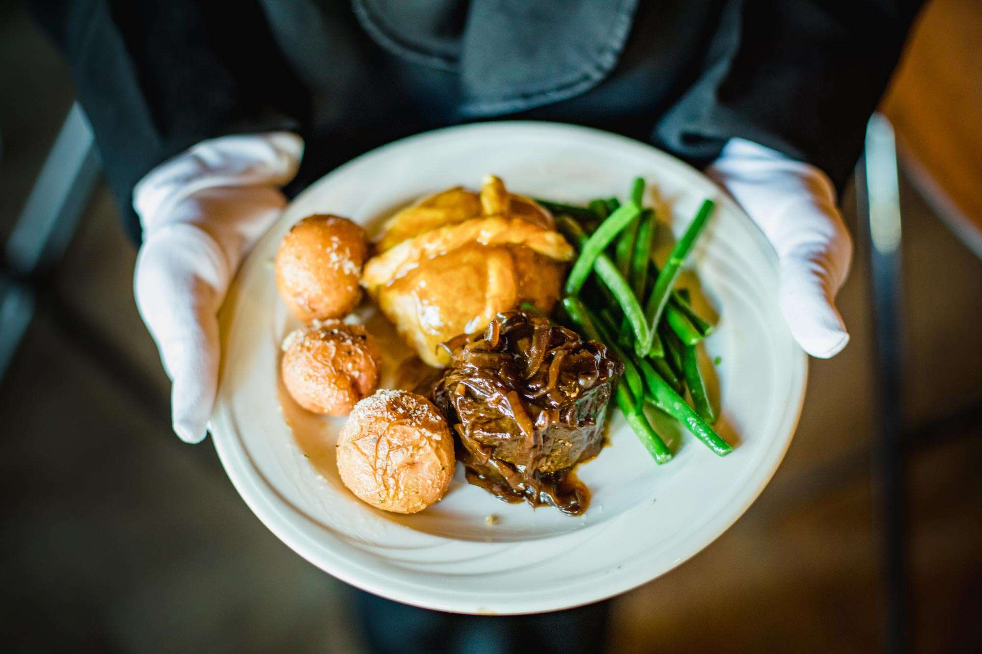 trio plate of steak, chicken encroute, potatoes and vegetables