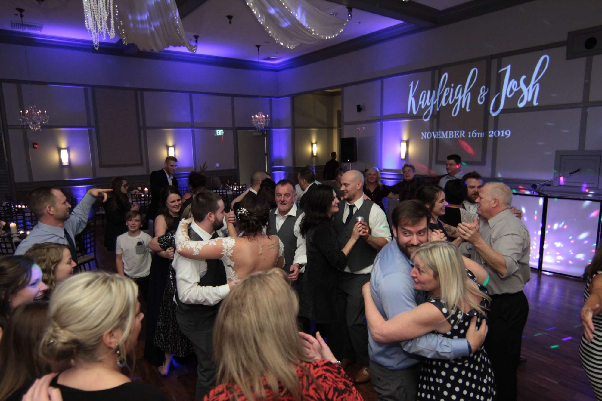 the-wedding-djay-music Digital monogram of wedding couples on wall as wedding guests dance