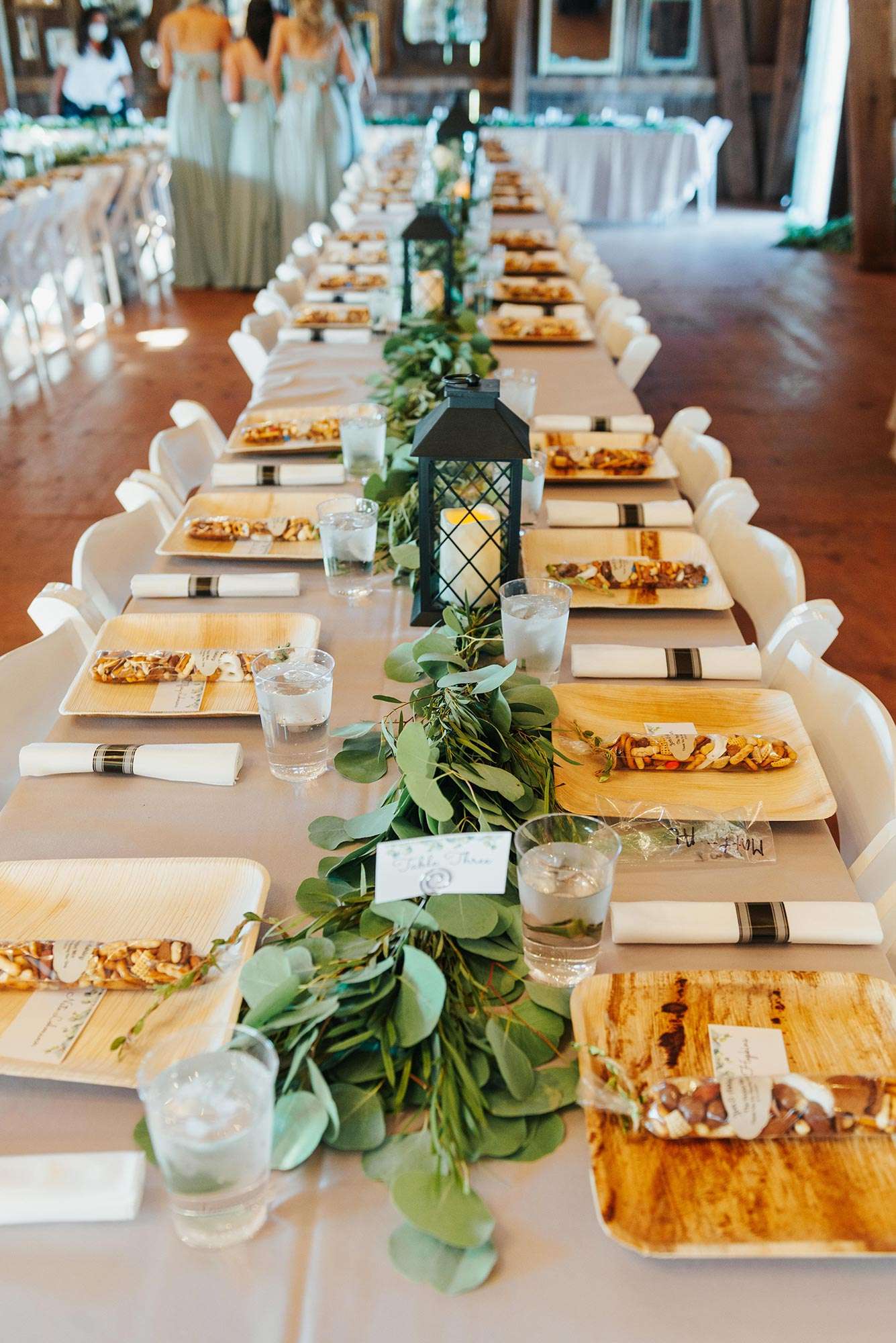 Reception table settings with simple greenery and black lanterns