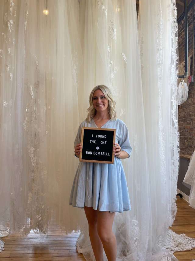 Future bride holding sign that reads