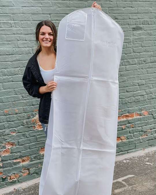 Happy bride with her bagged wedding gown at Bon Bon Belle Bridal