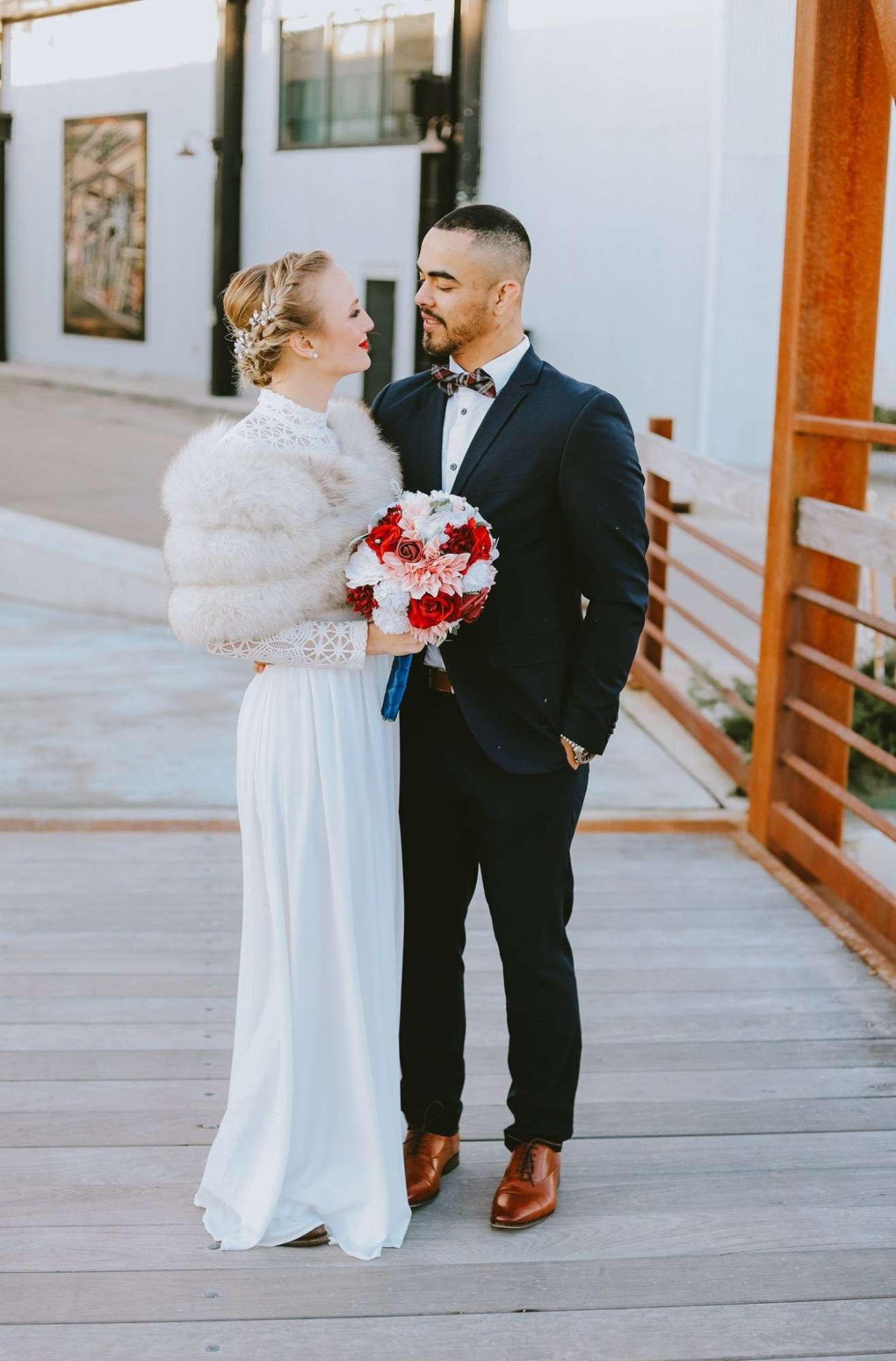 Bride and groom gaze at each other on boardwalk outside the Ironworks Hotel Beloit