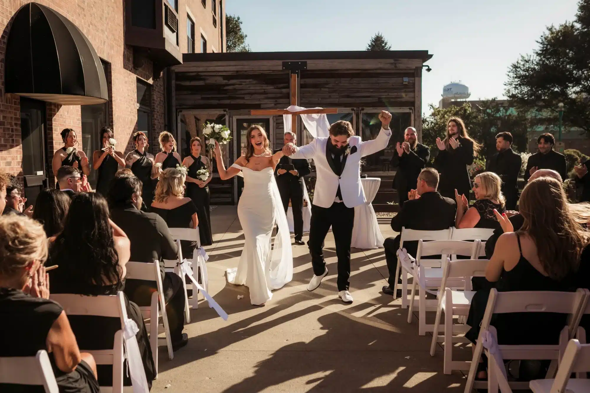 Bride and groom celebrate as they process down the aisle after their wedding ceremony at Ironworks Hotel Beloit.