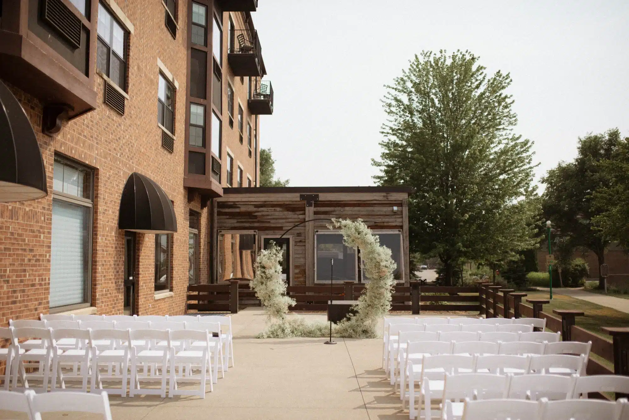 Outdoor wedding ceremony setup at Ironworks Hotel with beautiful circle arch accented with white flowers.