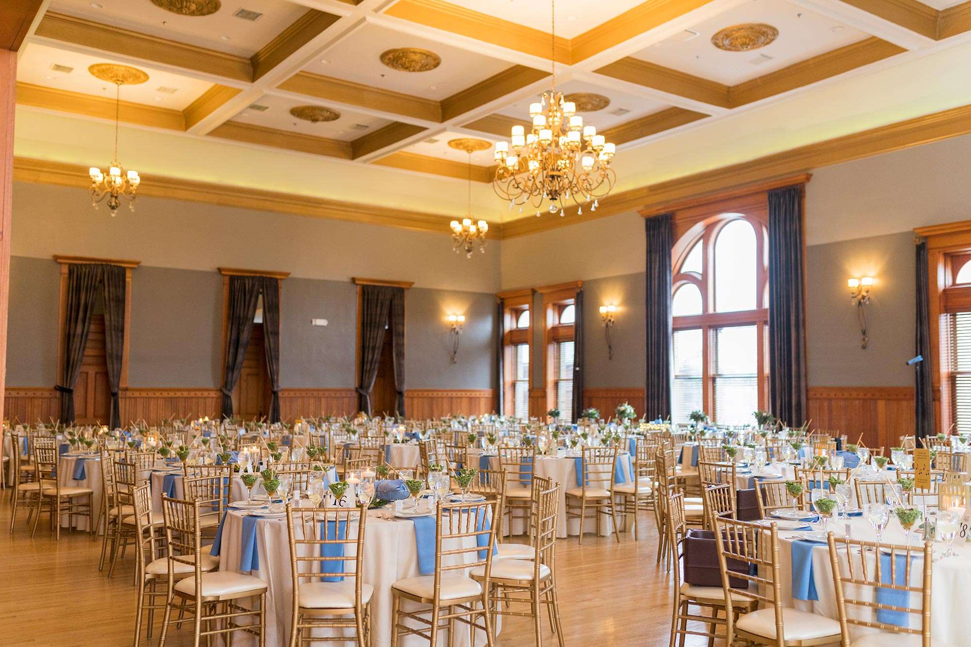Round guest tables with blue linens at Historic Courthouse 1893