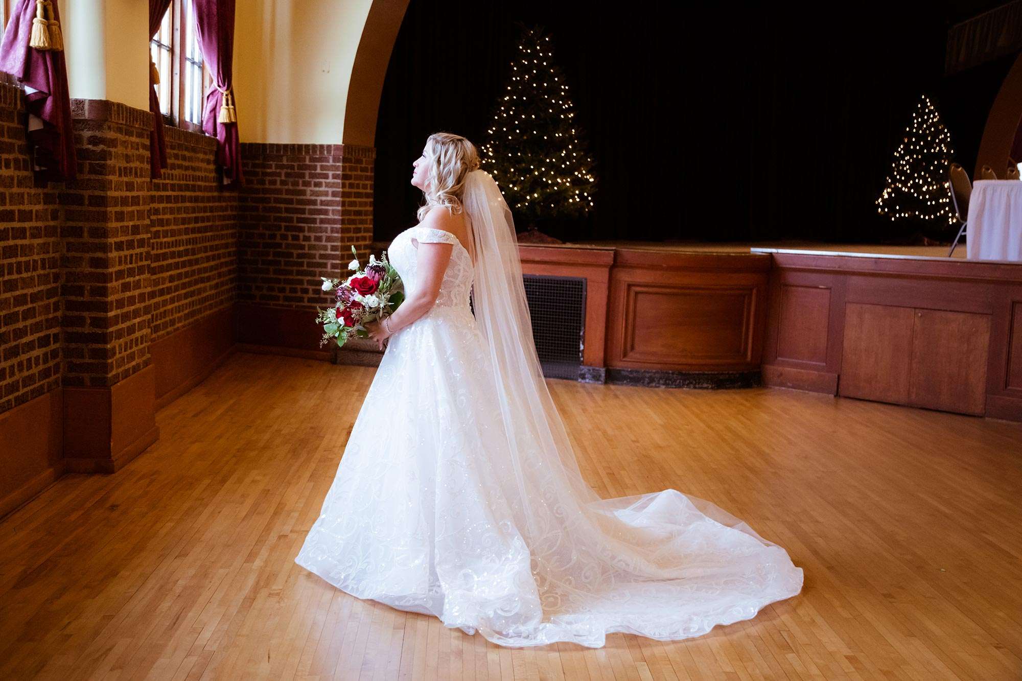 Karrie looks up and out a window with a side view of her ensemble from Amelishan Bridal
