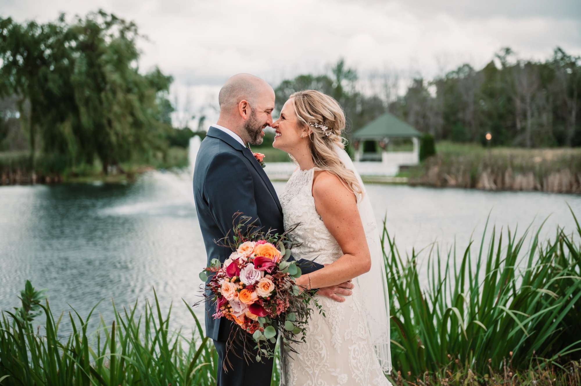 The Florian Event Venue kissing in front of the pond with fountain.
