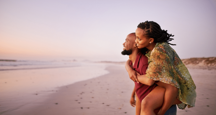 Couples enjoying the sunset on their Caribbean beach honeymoon and vacation.