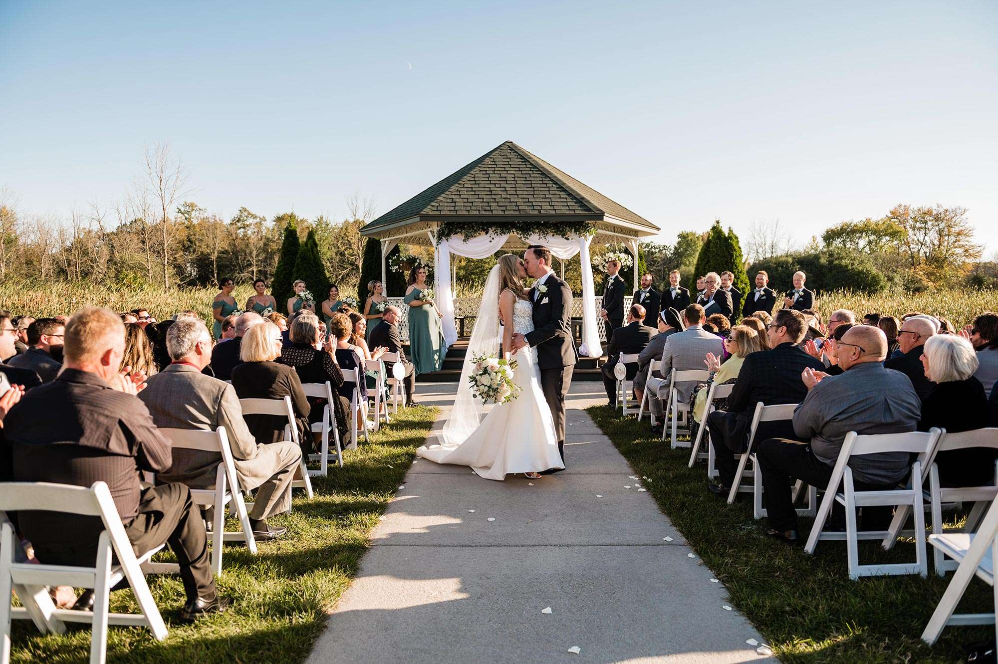 couple sharing a kiss during recessional – the florian event venue Complete Weddings + Events | Event Planning