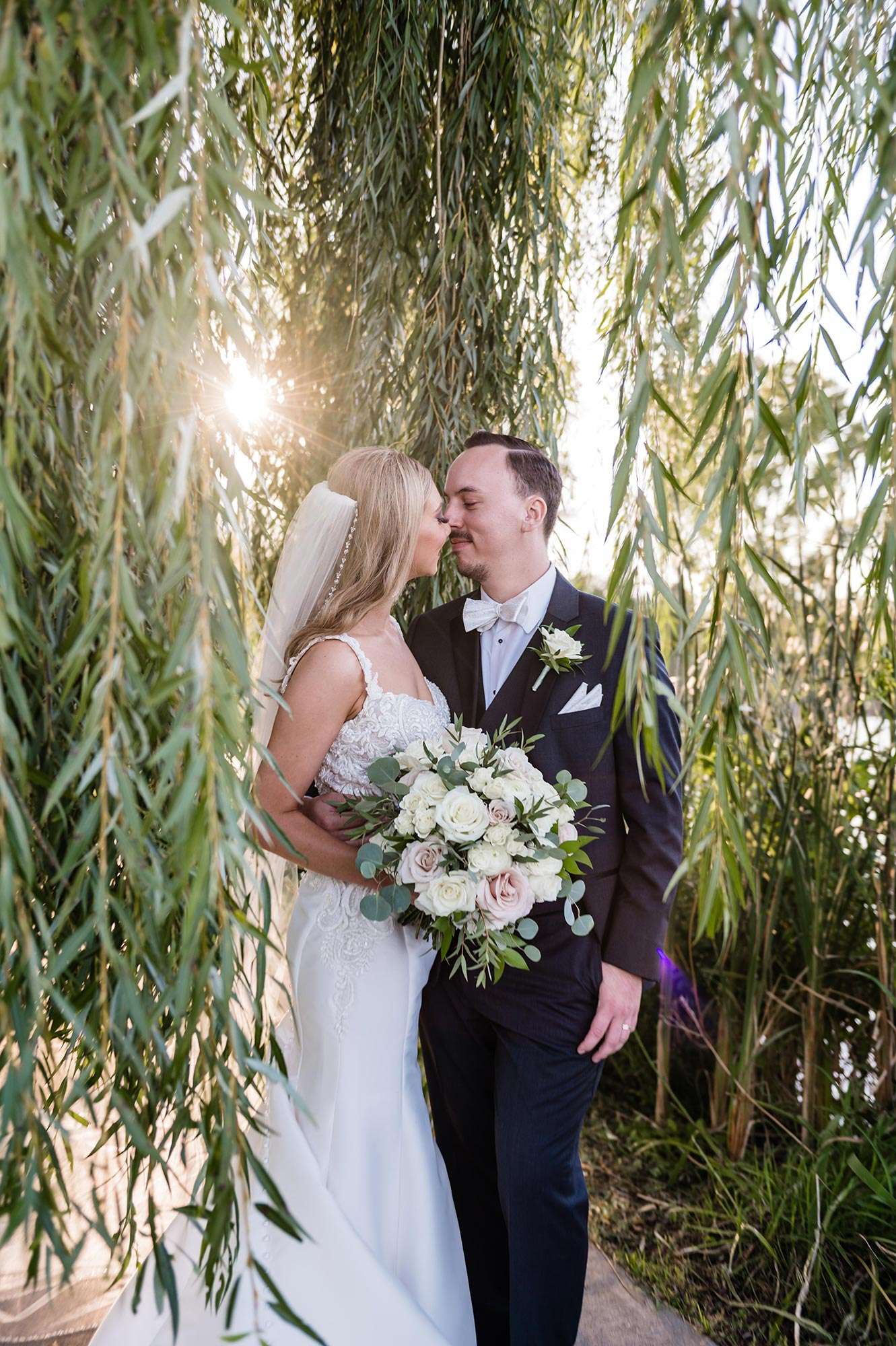 couple sharing an eskimo kiss under the willows - the florian event venue