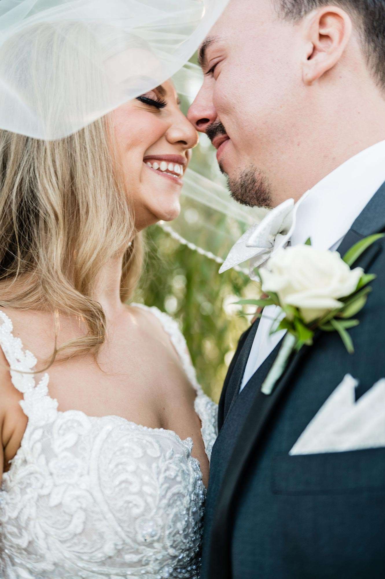 couple sharing a tender moment under bride's veil - the florian event venue