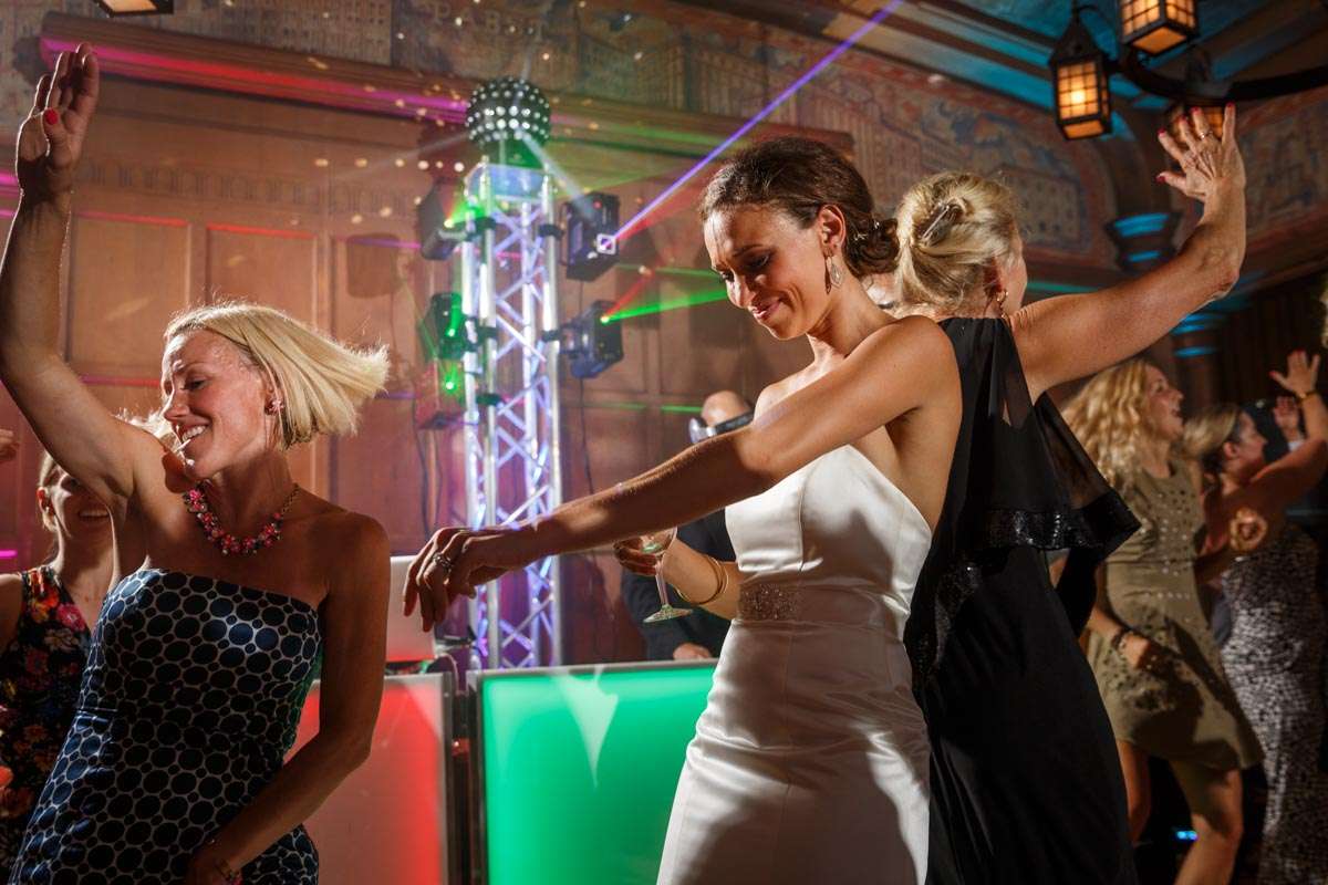 Guests joyfully dancing to vibrant lights and music in the lively Blue Ribbon Hall at Best Place at Historic Pabst Brewery.