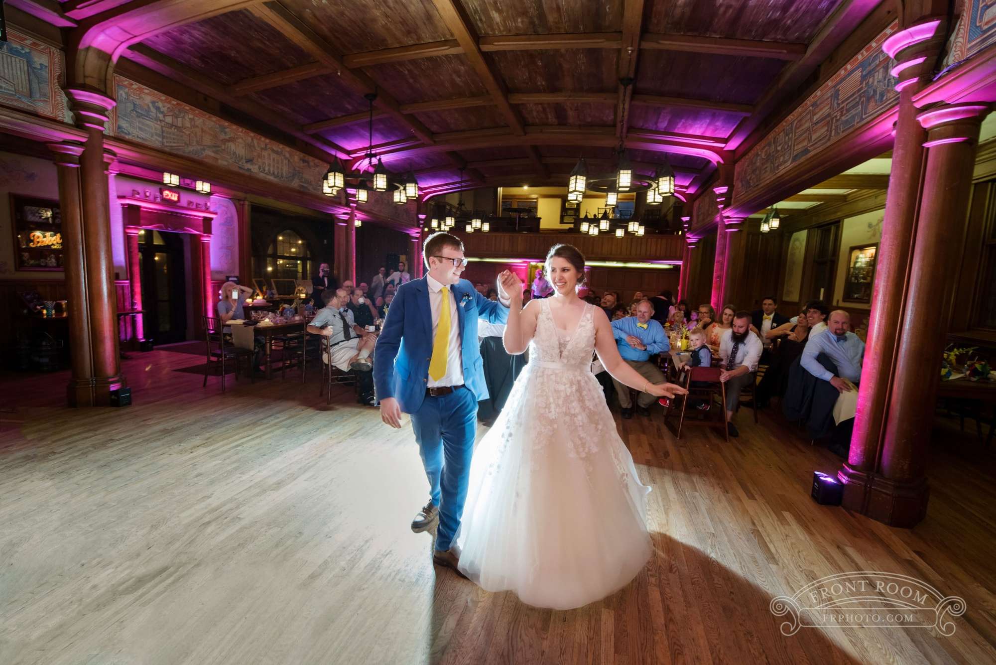 A couple gracefully dancing under soft lighting on the spacious Blue Ribbon Hall dance floor at Best Place at Historic Pabst Brewery.