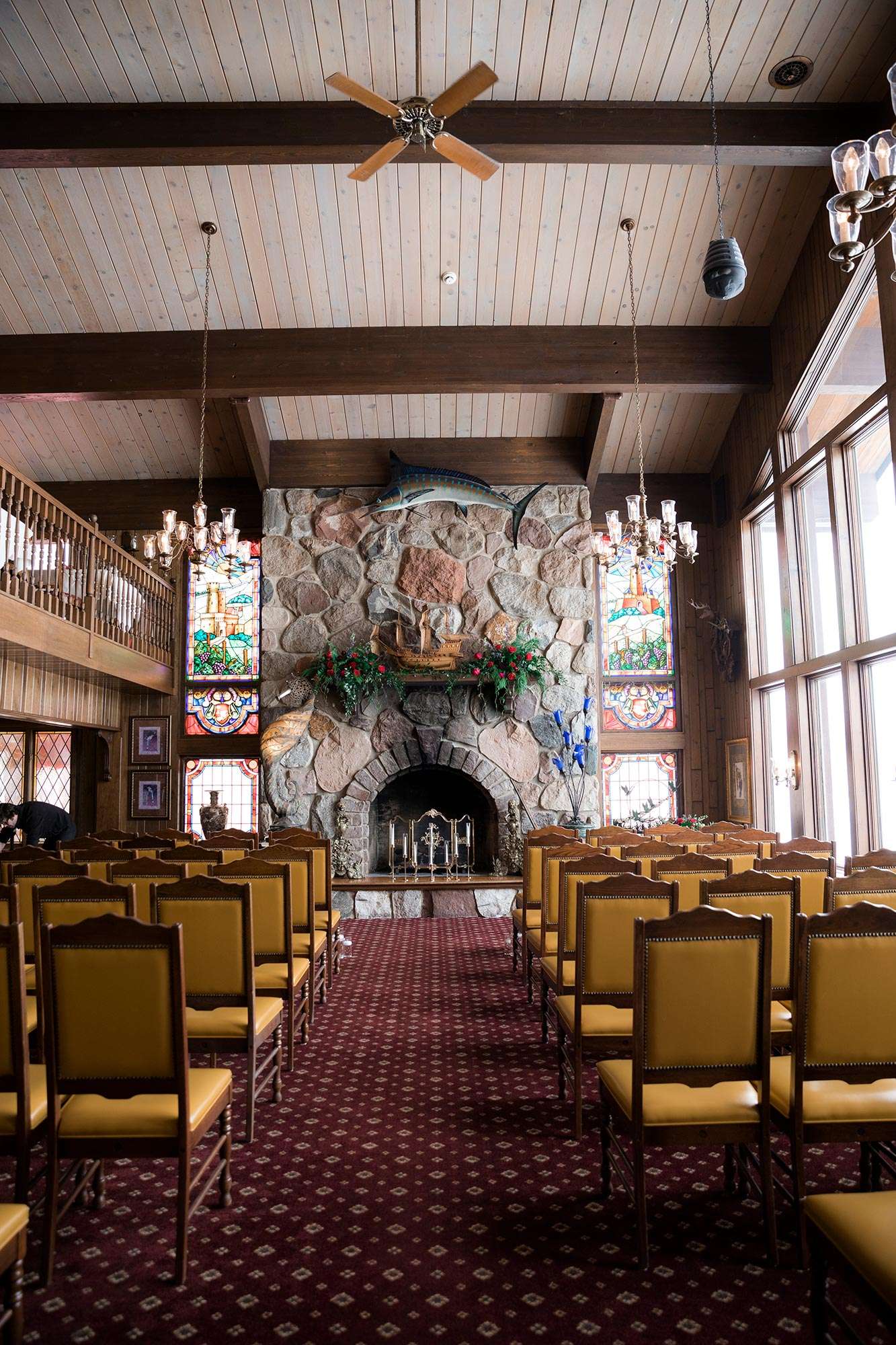empty ceremony space in Golden Mast's fireplace room with mustard leather chairs set up for guests