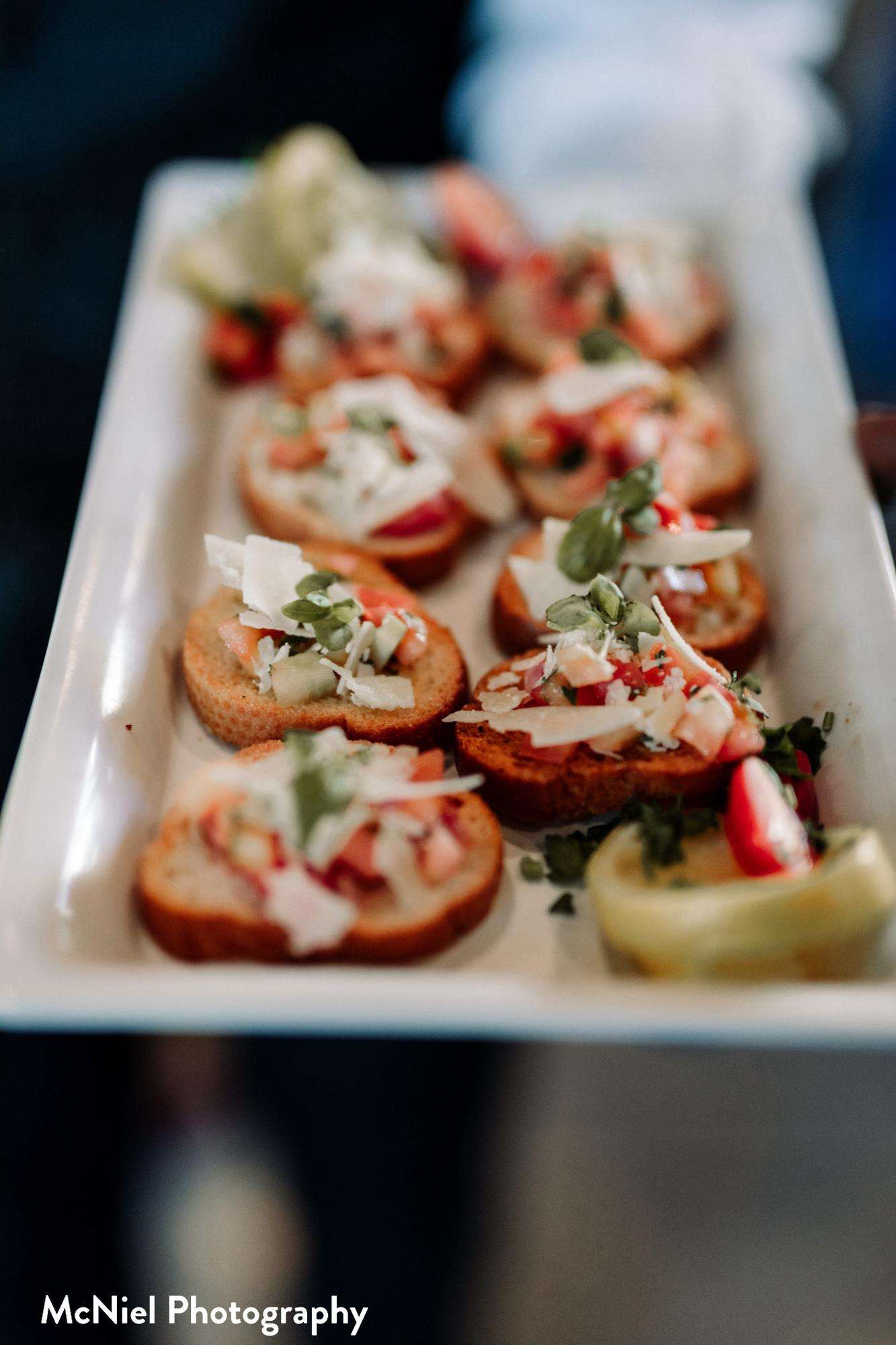 A beautifully arranged plate of fresh bruschetta appetizers, prepared by Saz's Catering, showcasing attention to detail and vibrant ingredients.