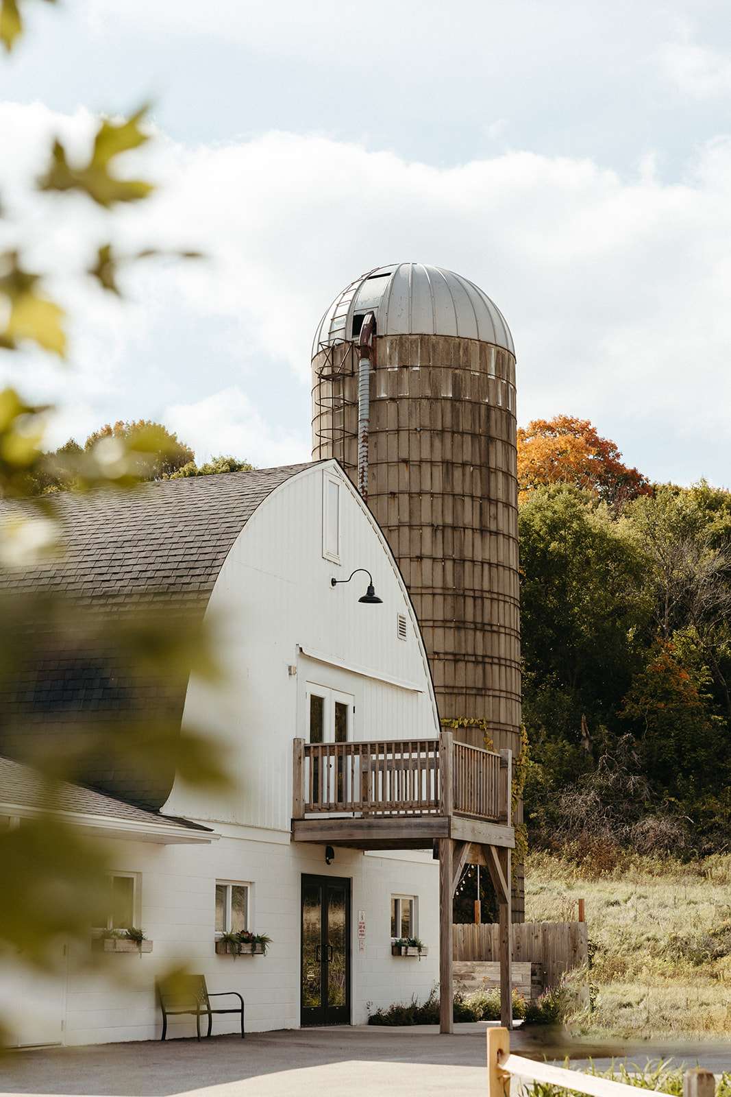 A breathtaking view of The Bowery nestled between sprawling fields and towering trees. The expansive property offers a beautiful contrast of rustic charm and modern elegance, making it the perfect canvas for your celebration.