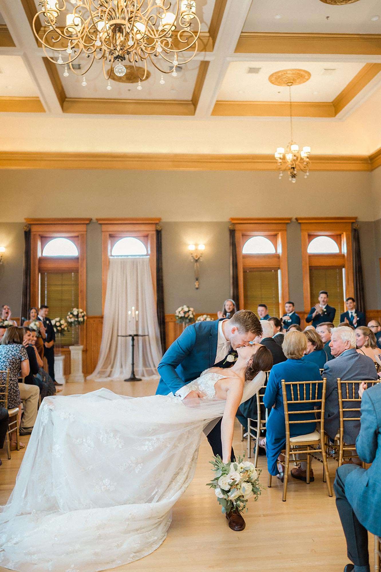 Groom dipping bride for a kiss at end of aisle after recessional