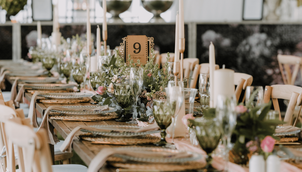Rustic wedding reception table decor with greens and pinks.