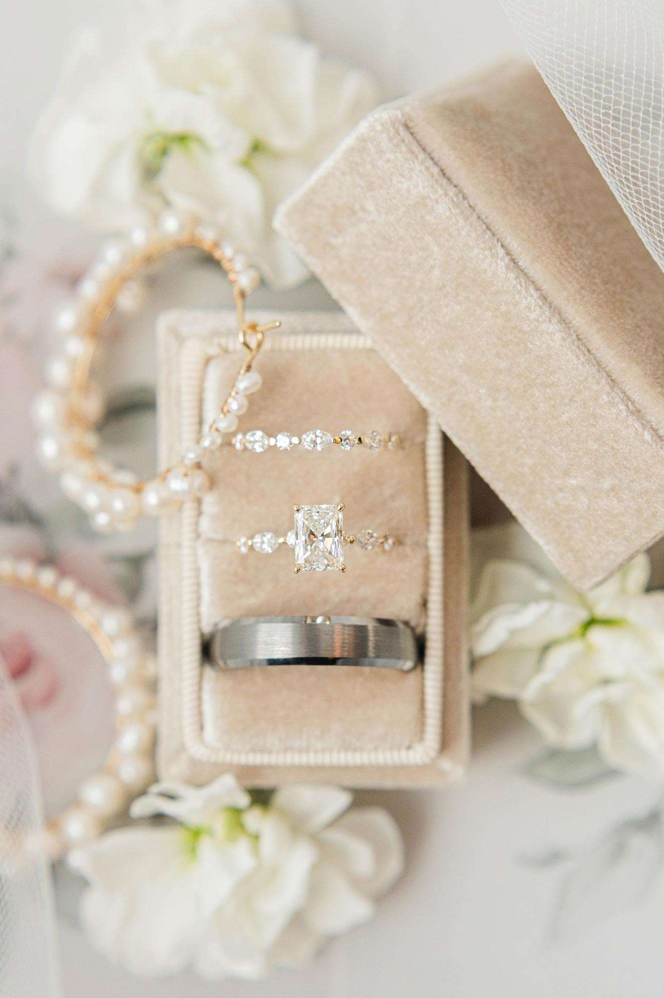 wedding ring and bands from Private Dealer in tan velvet box with pearl hoop earrings among white flowers wedding ring and bands from Private Dealer in tan velvet box with pearl hoop earrings among white flowers