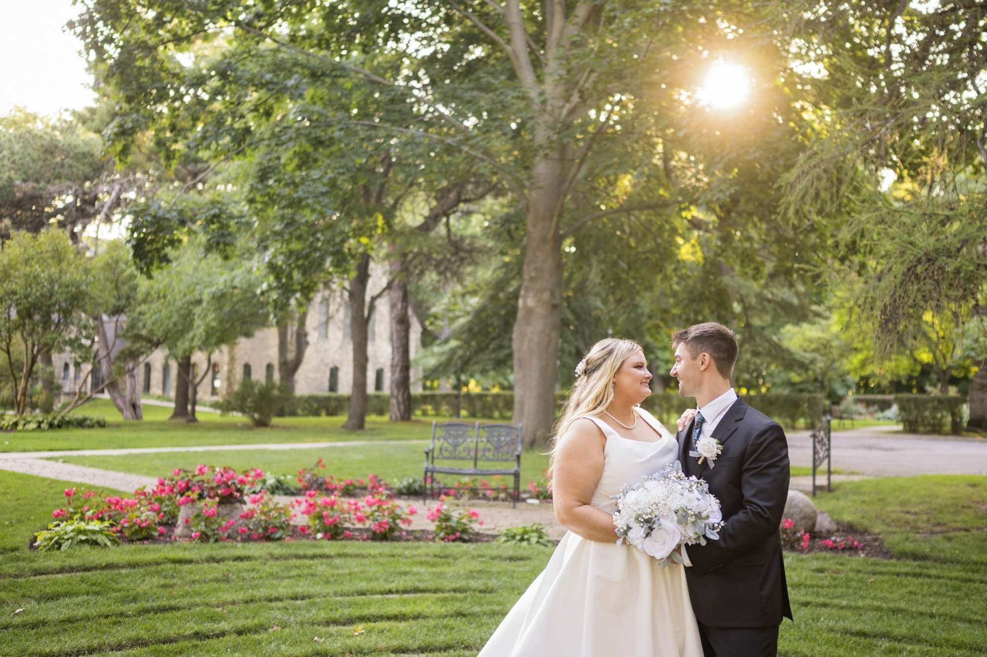 Bride and groom posing as they look at each other in front of the gardens at The Dekoven Center.