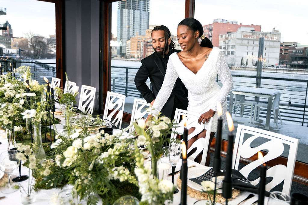Bride with elegant gown and groom at the modern head table setup for their wedding at Northern Lights Event Venue