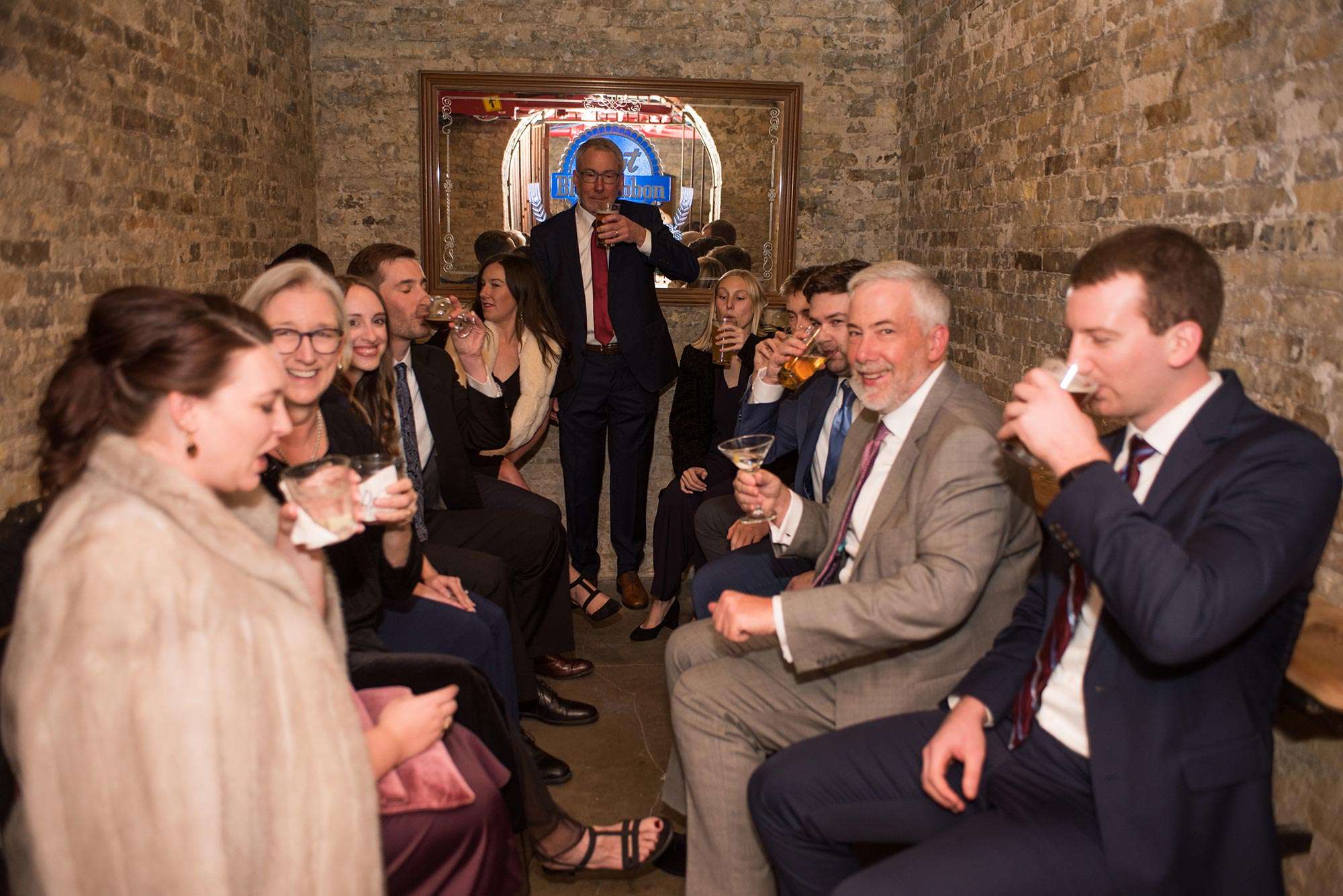 guests enjoying cocktails seated on benches in jail cell at Pabst Best Place