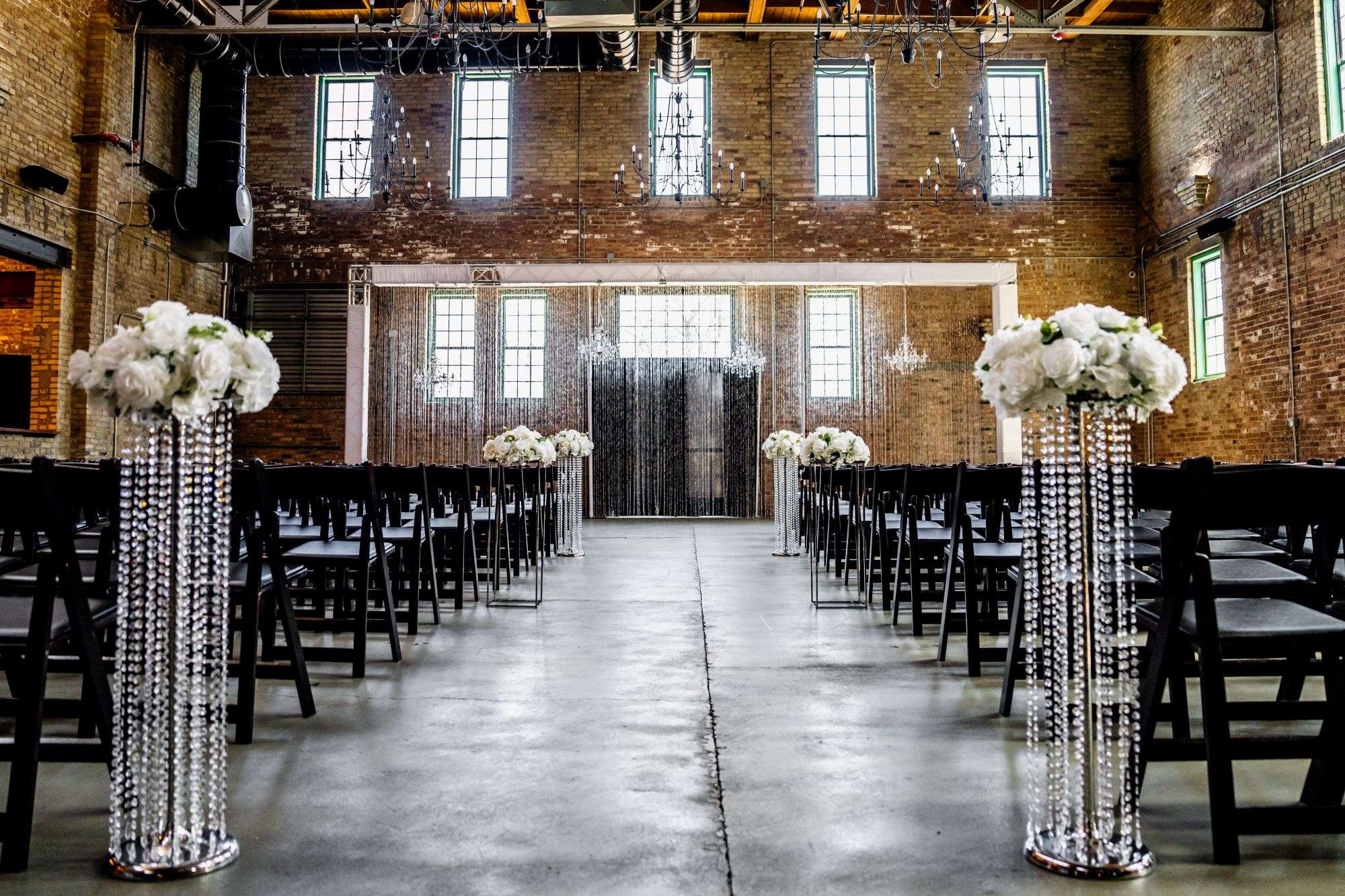 Ceremony setup with black, white and crystals in the main room of The Factory on Barclay with cream city brick walls.