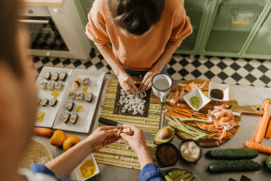 Couple at their kitchen counter making homemade sushi together.
