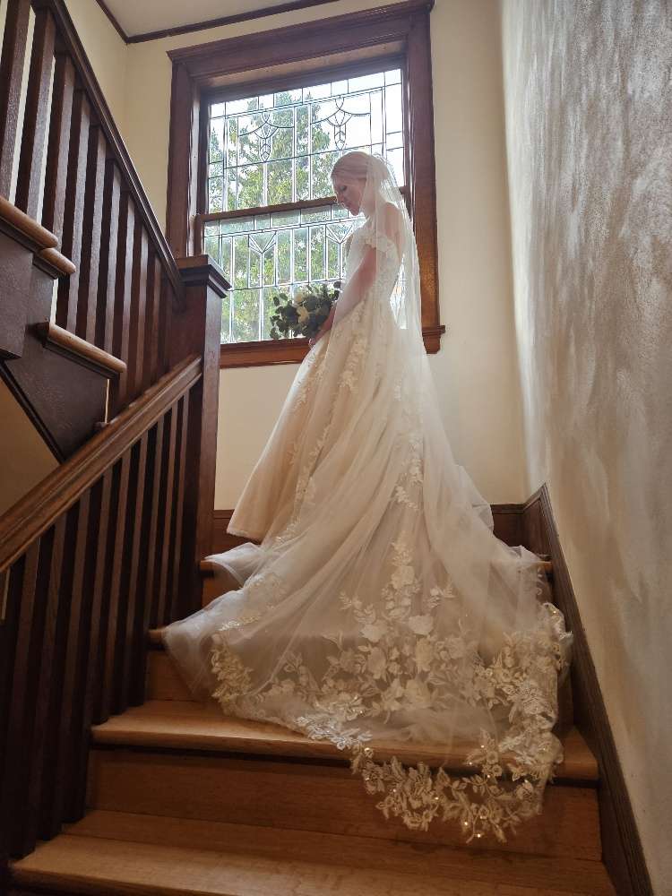 Long lace bridal gown train on traditional wood staircase at Schwartz Family House in Hartford.