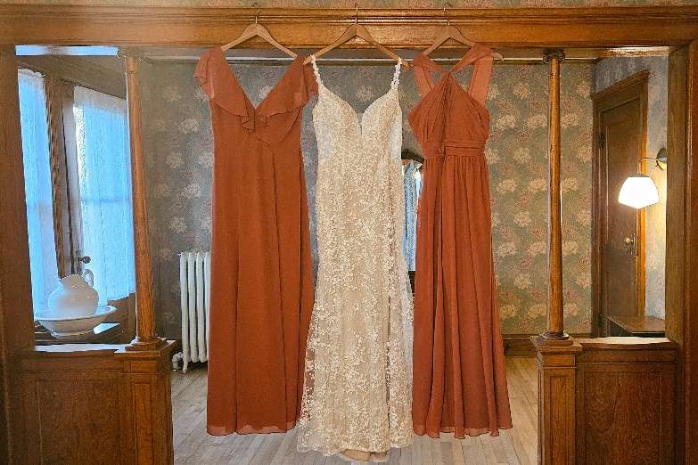 Burnt orange bridesmaid dresses and bridal gown displayed at Schwartz Family House in Hartford.