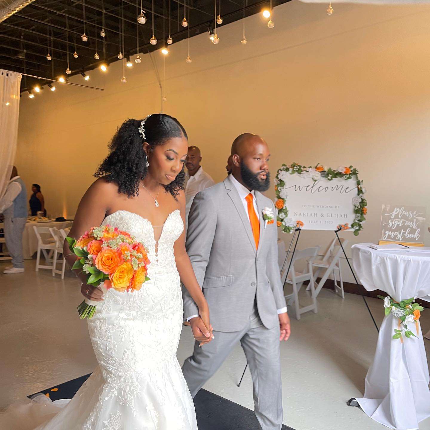 Newlyweds walking hand in hand at The Mitch, surrounded by modern decor and a welcoming ambiance.
