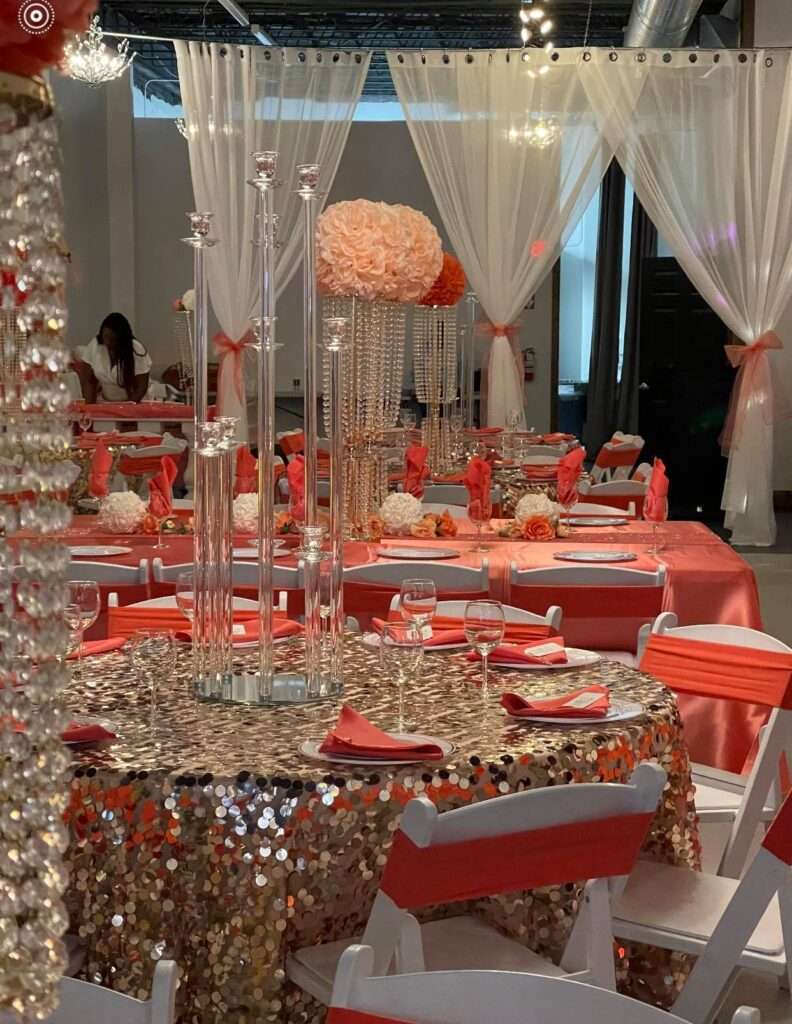 A glamorous table arrangement at The Mitch with shimmering gold tablecloths, coral decor, and luxurious floral accents.